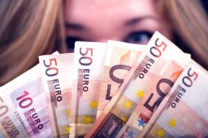 occhi di donna che tiene in mano banconote in euro