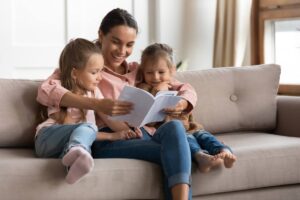baby sitter legge libro a due bambini