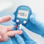 medico che buca il dito al paziente per misurare il diabete