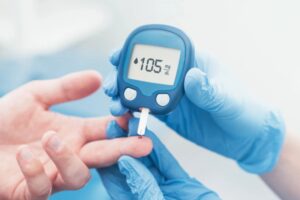 medico che buca il dito al paziente per misurare il diabete