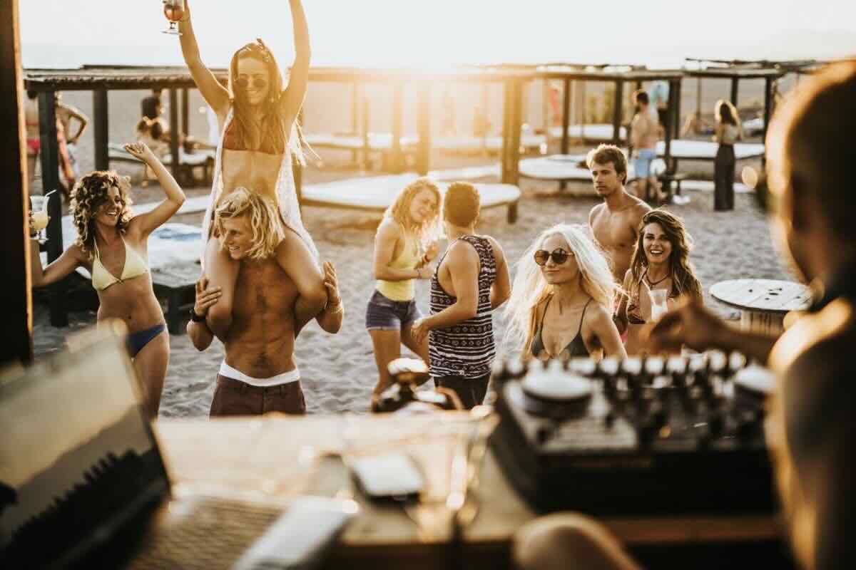 Giovani ragazzi e ragazze si divertono in spiaggia