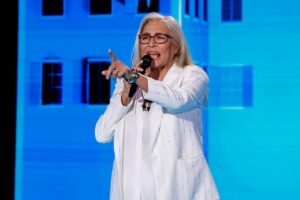 Mara Venier che parla con il microfono e punta il dito