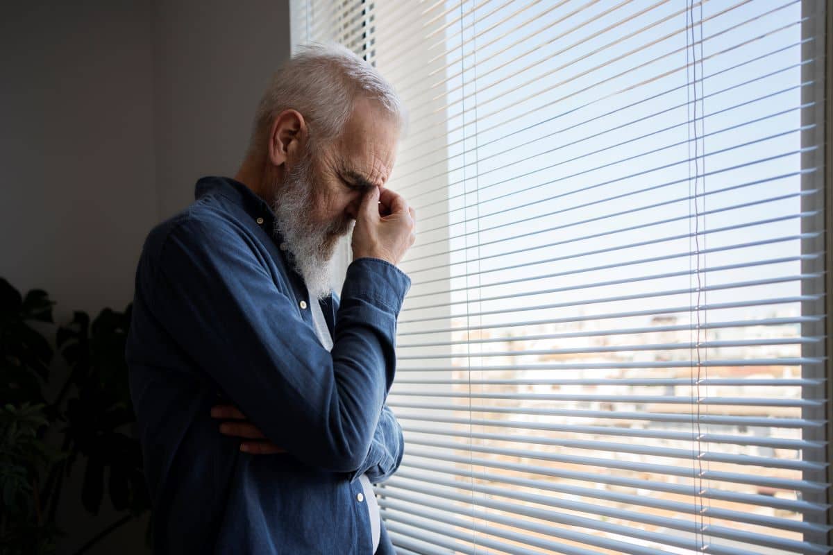 Uomo anziano triste alla finestra