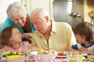 Nonni con due nipotini a tavola