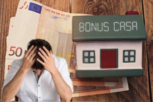 uomo con mani tra i capelli banconote e casa con scritta bonus