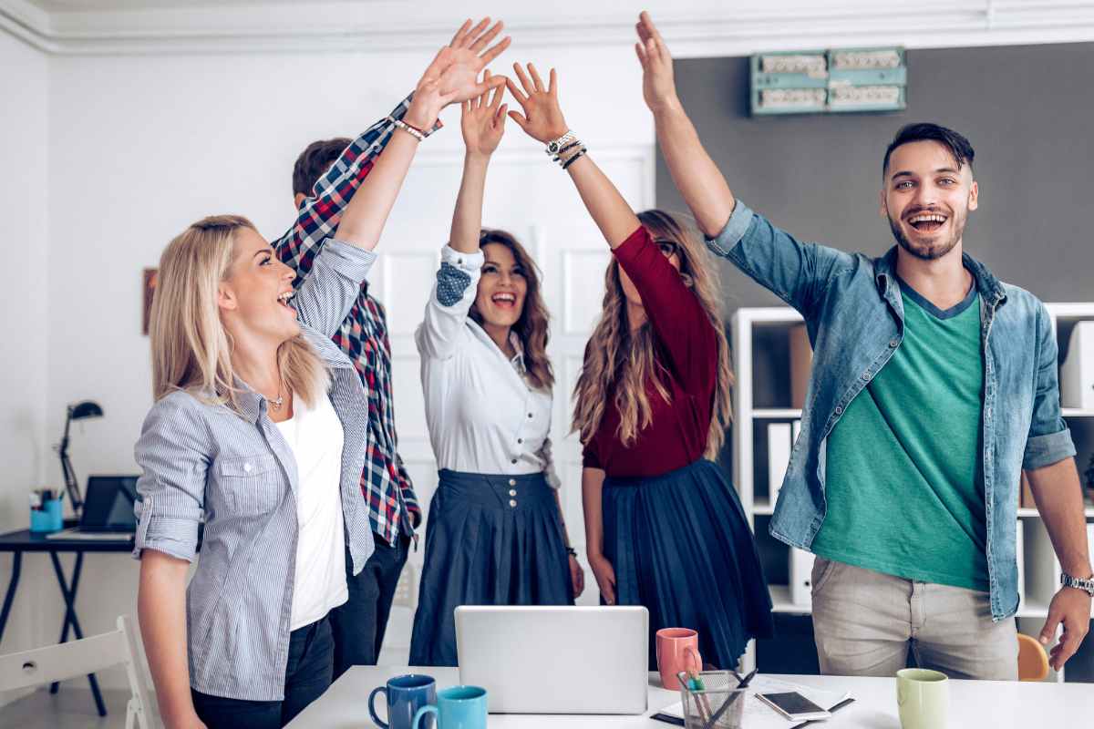 ragazzi festeggiano con mani in alto a lavoro