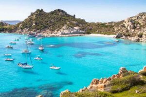 Mare, barche, vegetazione su rocce